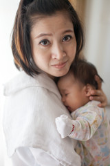 Mom is holding and kissing her baby with love