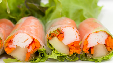 Salad roll on a wood dish in white background