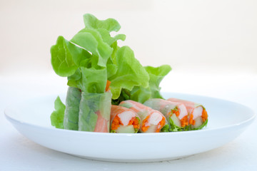 Salad roll on a wood dish in white background