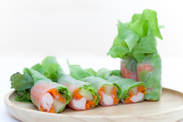 Salad roll on a wood dish in white background