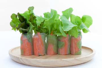 Salad roll on a wood dish in white background