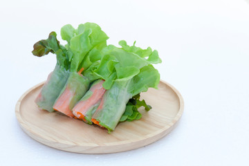 Salad roll on a wood dish in white background