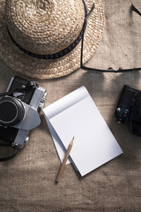 Notebook,cameras,sunglasses and a hat for travel