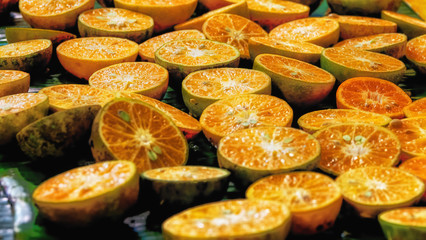 Tangerine fruit sliced in half to prepare as orange juice