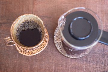 selective focus cup of coffee drip on wooden table , filtered coffee