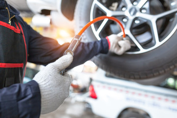Close-Up Of Hand holding pressure gauge for car tyre pressure measurement in auto Car repair shop © tong2530