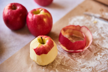 Ripe peeled apple. Baking ingredients placed on table, ready for cooking. Concept of food preparation, white table on background