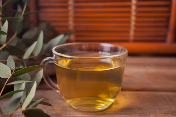 Cup of hot green tea on the old wooden table