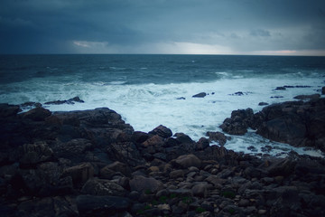 Beautiful landscape view of the rocky coast of the Atlantic Ocean during a cloudy sunset. Spain