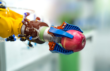 robot hand is holding a red apple. Modern technology and robotics.