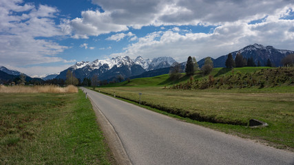 Fototapeta na wymiar Walgau im Frühling mit grünen Wiesen und Schnee auf den Bergeb