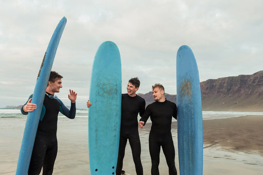 Excited men with surfboards