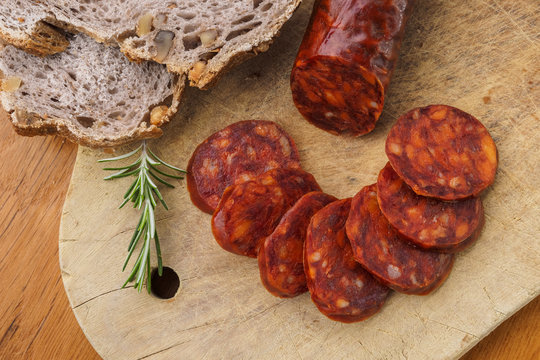 Iberian chorizo, Spanish chorizo ​​or Spanish sausage cut into slices on a wooden board with rustic bread