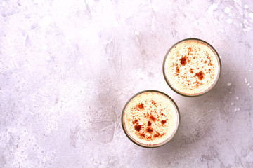 Glass of eggnog and candy cane.