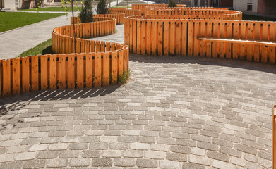 The walking area is surrounded by a decorative wooden fence of curved shape. Paved with tiles of...