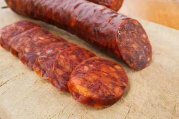 Iberian chorizo, Spanish chorizo ​​or Spanish sausage cut into slices on a wooden board