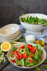 Vegetarianism and healthy food ,raw food. Cooking salad with vegetables, Kitchen table with dishes,plates and vegetables and herbs