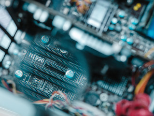 A craftsman who checks something with the magnifying glass on the micro schema in the computer