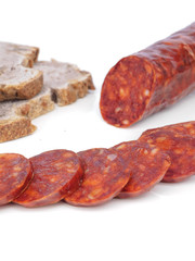 Iberian chorizo, Spanish chorizo ​​or Spanish sausage with its slices placed one on another on a white background with its reflection with rustic bread