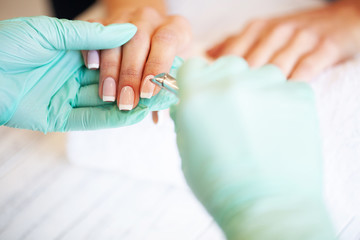 New manicure. Side view of the process of manicure in salon. Professional manicurist provides a service to the client