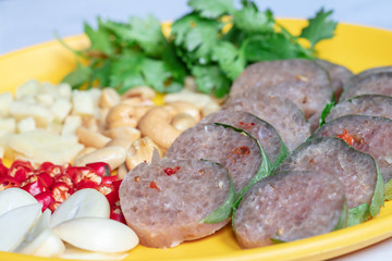 Close up Thai cuisine : Thai sour pork with red chili,ginger,garlic,coriander and cashews in the yellow dish.