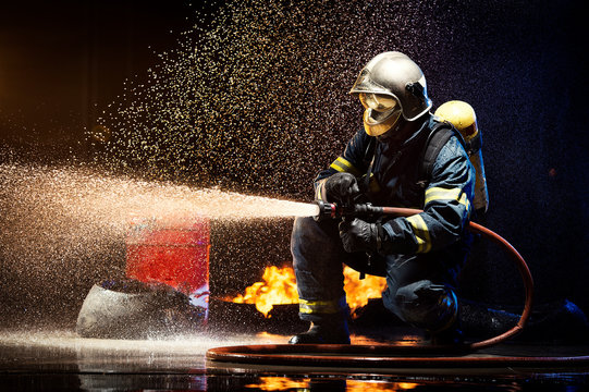 Anonymous fireman fighting fire with water