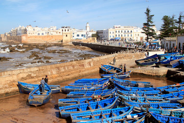 Essaouira Ramparts aerial panoramic view in Essaouira, Morocco with traditional blue fishing ships. Essaouira is a city in the western Moroccan region on the Atlantic coast. - obrazy, fototapety, plakaty