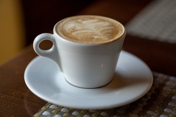coffee in a white cup on the table.