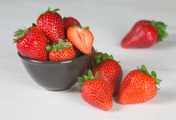 Heap of fresh strawberries in woods on rustic white wooden background 