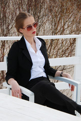 Young business woman with sunglasses sitting in outdoor cafe and relax