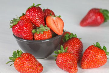 Heap of fresh strawberries in woods on rustic white wooden background 