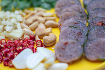 Close up Thai cuisine : Thai sour pork with red chili,ginger,garlic,coriander and cashews in the yellow dish.