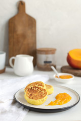 Traditional russian syrniki or cottage cheese pancakes served with mango, coffee, milk pitcher, healthy breakfast