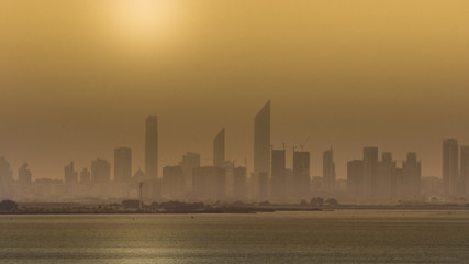 Golden hour on the skyline of a modern city. Sunrise over high buildings near the ocean in UAE. Beautiful sky line of a big new arabian metropole. Sunset on a urban landscape in the middle east