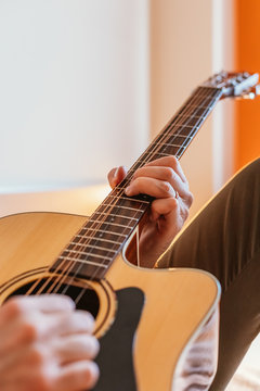 Man playing the guitar on the bed