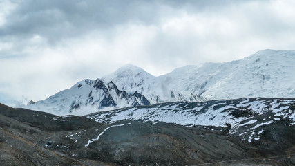 Fototapeta premium View on Himalayas from Annapurna Circuit Trek, Nepal. Sharp, snow covered slopes. Mountain looks unconquered. High altitude climbing. Barren slopes below the snow part. Snow avalanche possible.