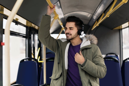 Young man listening to music with headphones in public transport