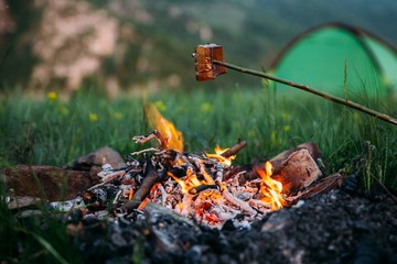 Fried bacon at campfire while camping outdoors.