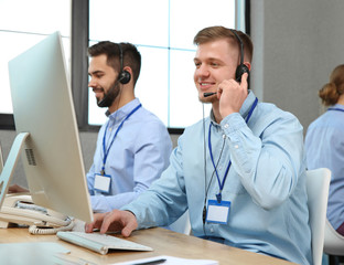Technical support operator working with colleagues in office
