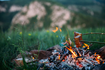 Fried bacon at campfire while camping outdoors.