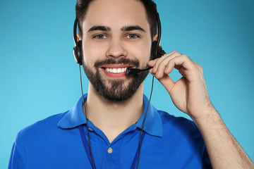 Portrait of technical support operator with headset on color background