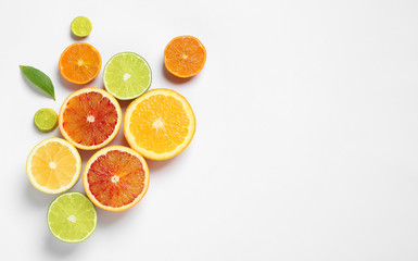 Composition with different citrus fruits on white background, top view