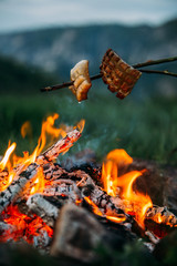 Fried bacon at campfire while camping outdoors.