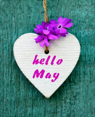 Hello May greeting card with decorative white heart and spring flowers on old blue wooden background.Springtime concept.