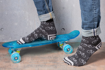 male legs in gray socks, on a blue skateboard, the concept of active life