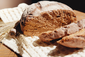 Fresh brown bread with spikelets on table, beautiful food still life