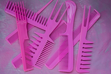 Pink bright comb for hairdressers. Beauty saloon. Tools for hairstyles. Colorful pink background. Barbershop. A set of different combs for hair