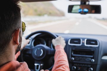 Young man driving a car, interior shot