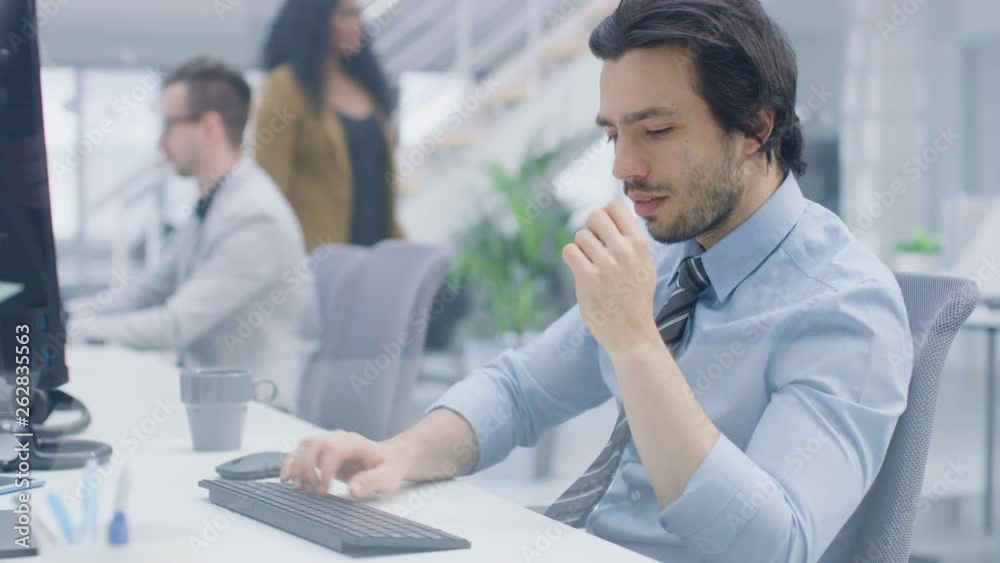 Poster portrait of handsome and confident shirt and tie wearing businessman uses desktop computer, typing o