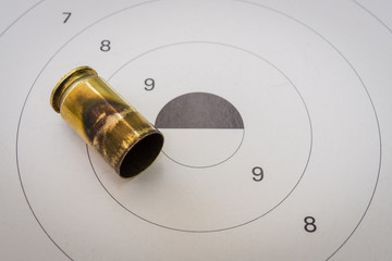 A 45 acp bullet with a paper target in the background